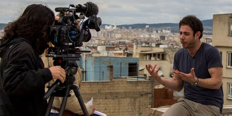 Journalist and cameraman on rooftop conducting interview