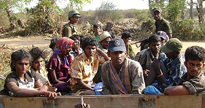 A disturbing picture of a group of young Tamils sitting at the back of a truck with Sri Lanka soldiers holding guns