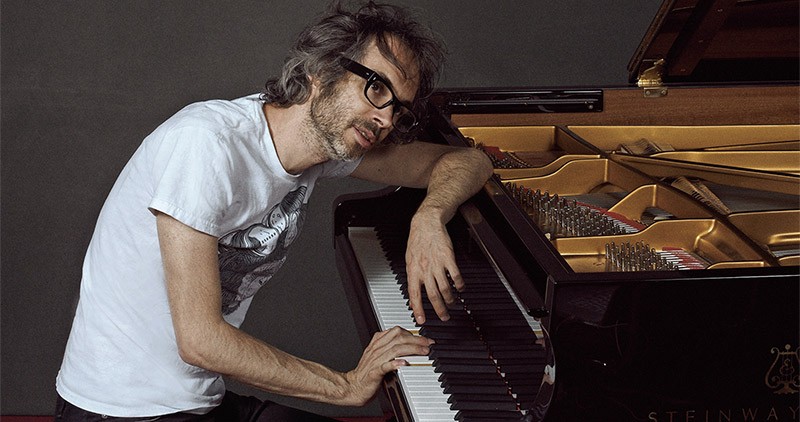Classical pianist James Rhodes sitting at a grand piano
