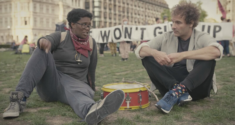 Alfie, a climate activist at an Extinction Rebellion protest sat with filmmaker Josh Appignanesi