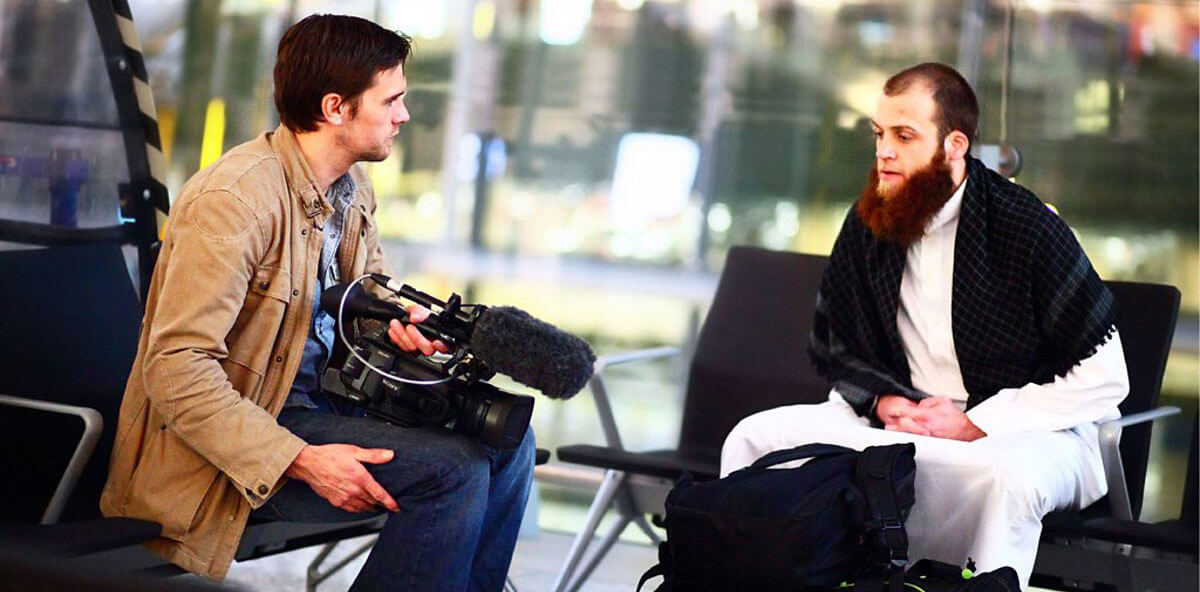 My Brother the Terrorist: Presenter/director Robb Leech with film camera interviews his brother who became a radical Muslim, both are seated